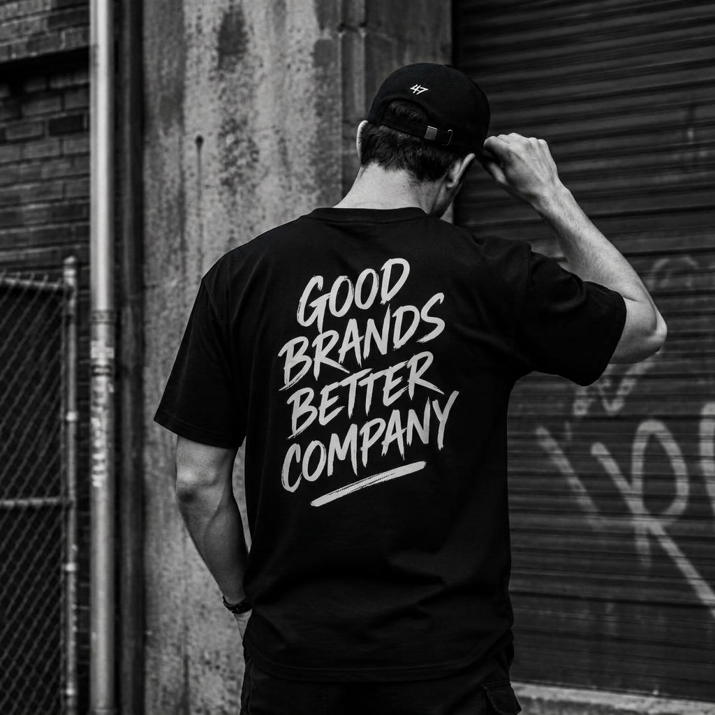 Person wearing a black Merch Riot tee with hand-lettered back print